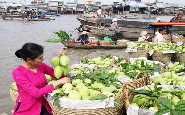 Small wooden boats on Mekong River are full of tropical fruits