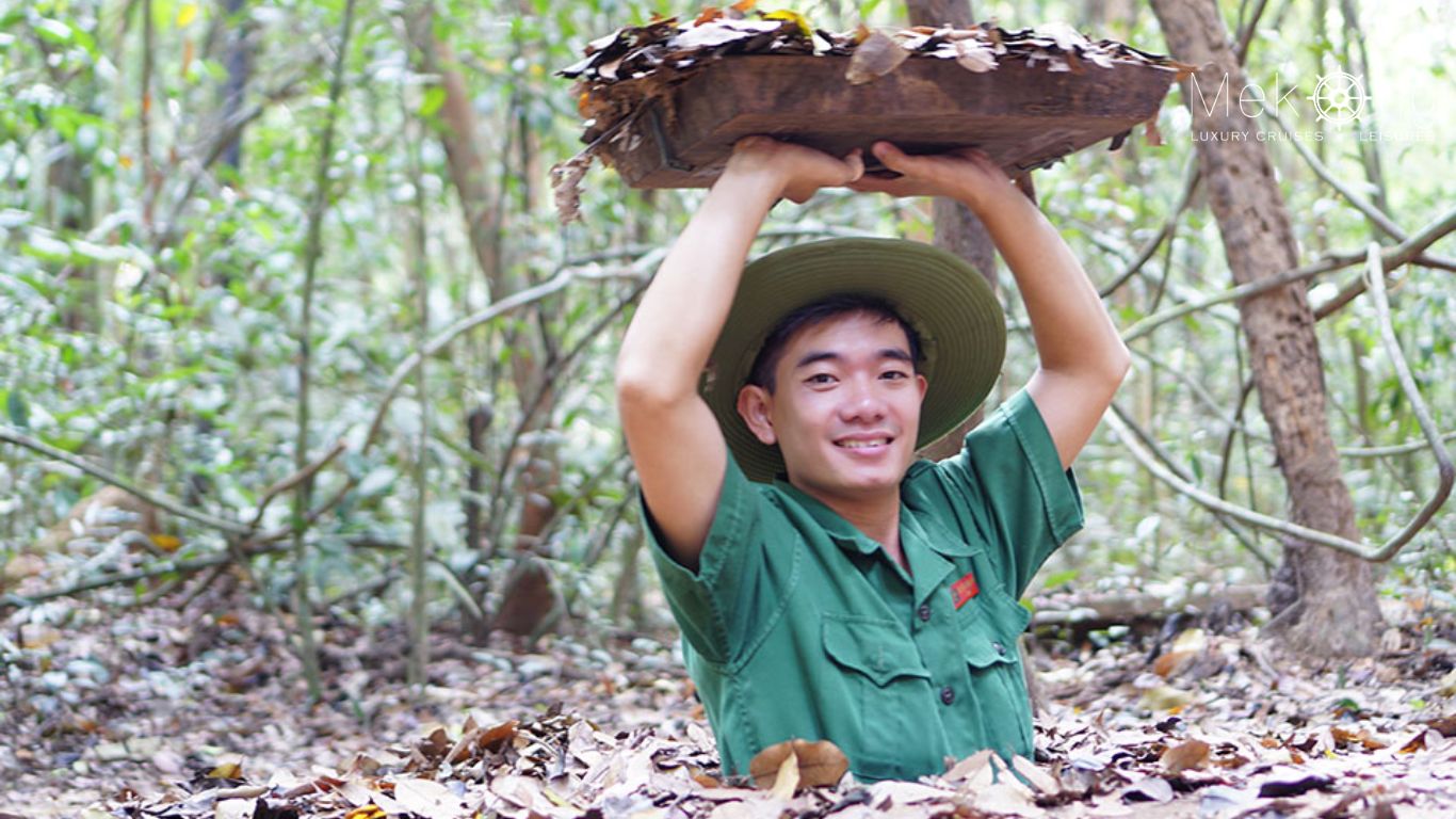 A man at the photo-posing hole at Cu Chi Tunnels