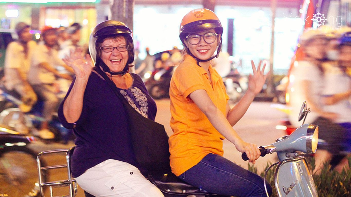 Driver and visitor to Ho Chi Minh City on a vespa scooter