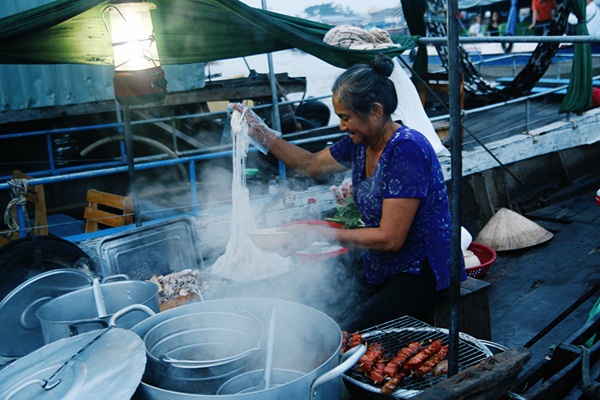 A woman sells nem nuong and Hu Tieu (rice noodle soup)