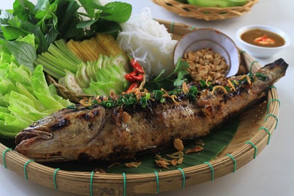 Grilled fish eaten with fresh vegetables which you can enjoy when exploring Mekong delta by boat