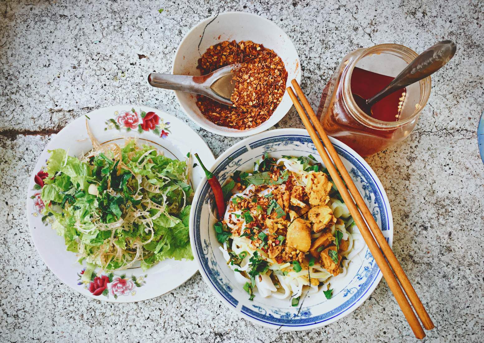 Quang noodle is served with fresh vegetables, chili and vinegar