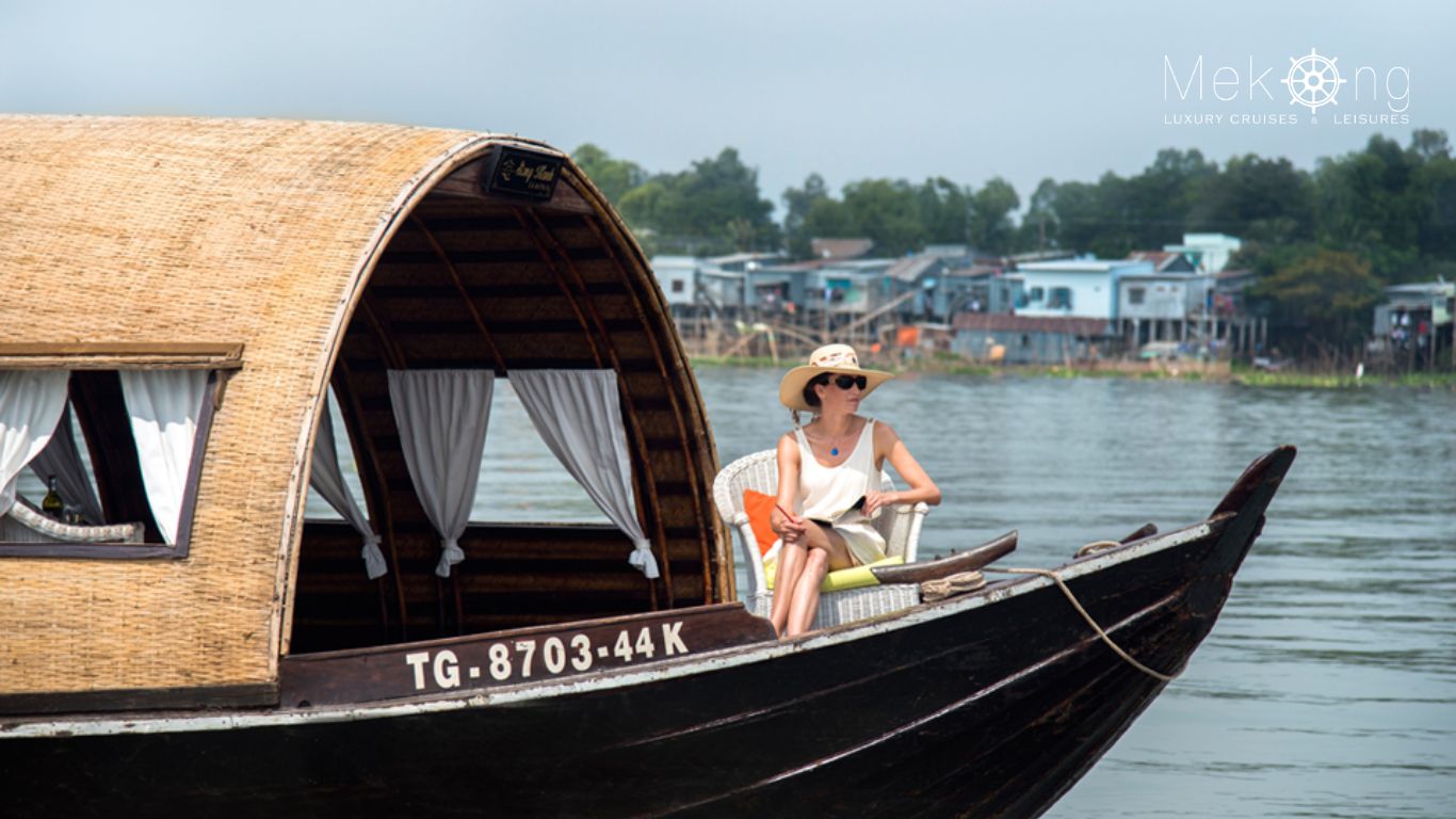 A woman sitting on the sundeck of the Song Xanh Sampan cruise boat on the Mekong River