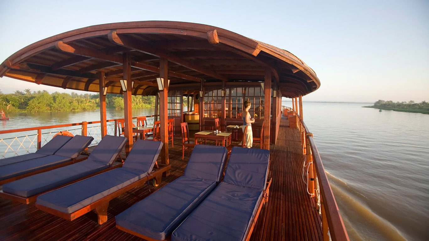 Sun loungers on the upper deck of a wooden river cruise ship, a relaxed way to see the Mekong Delta in November
