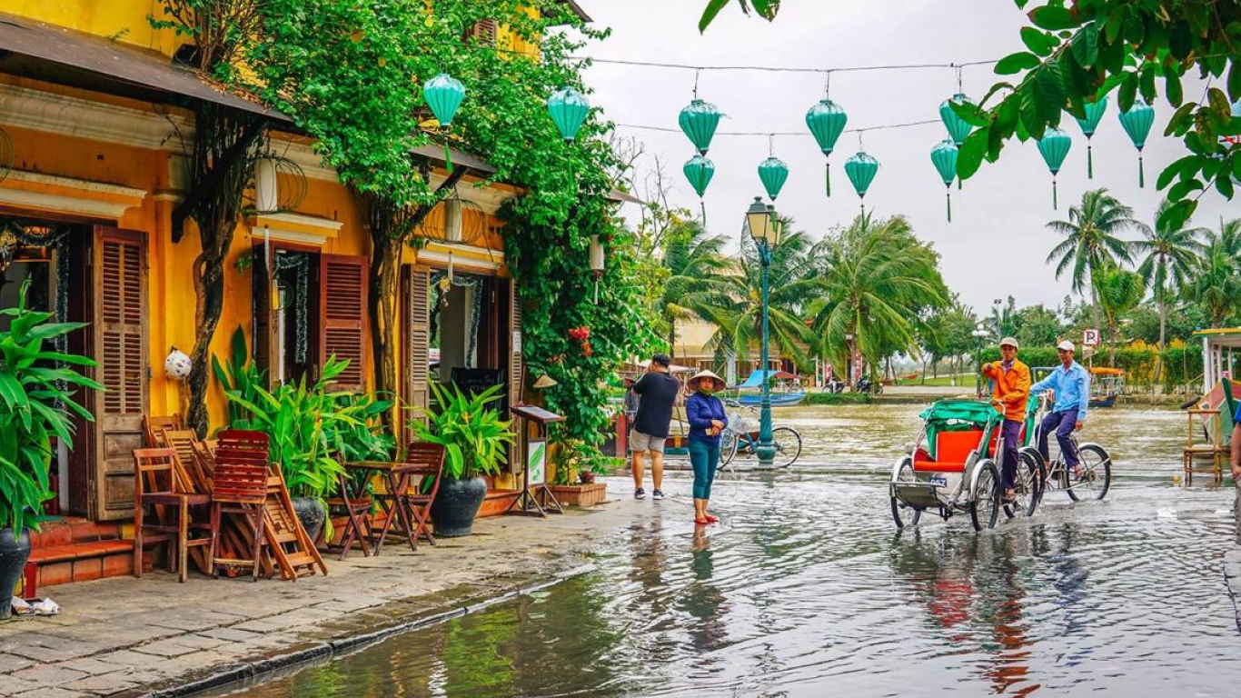 Flooded street in Hoi An’s ancient town in November with cyclos and teal lanterns