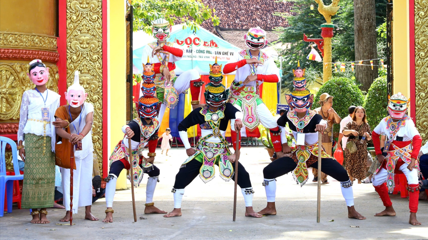 Dancers in colorful masks at a pagoda gate during Ok Om Bok in the Mekong Delta in November